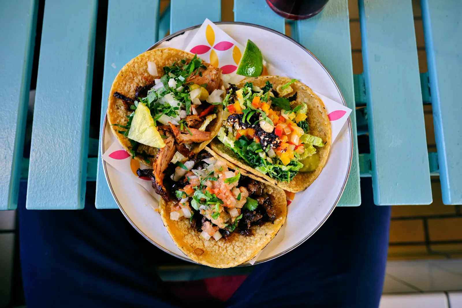 Fresh street tacos with lime on a blue table